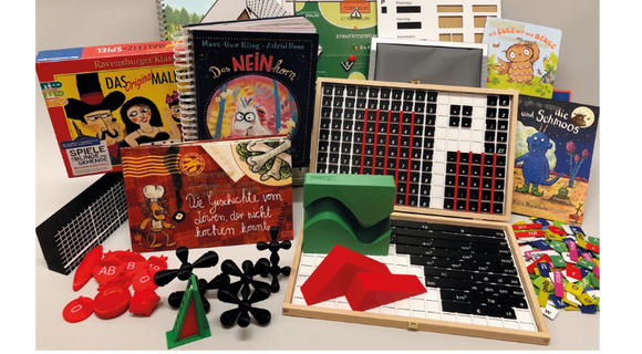 Ein Screenshot der Website der "Blinden-Mediathek der Dinge". Auf einem Foto sind verschiedene Medien wie Bücher und Spiele abgebildet. Darunter steht: "Die Deutsche-Blinden-Mediathek (DBM)