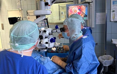Prof. Dr. Frank Holz bei der Implantation des Port-Delivery-System mittels eines mikrochirurgischen Eingriffs im OP der Augenklinik bei einem Patienten mit AMD.