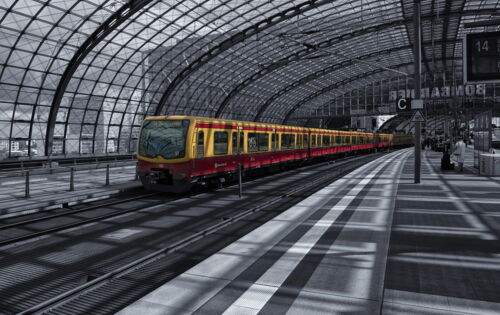 Ein menschenleerer Bahnsteig mit weißem Leitstreifen, eingefasst von zwei dunklen Kontraststreifen.
