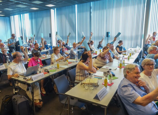 An langen Tischreihen sitzen die Delegierten des DBSV-Verbandstags. Vereinzelt halten sie Wahlkarten hoch.
