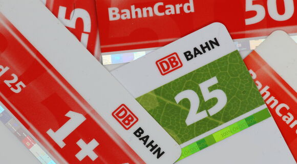 Mehrere BahnCards aus Kunststoff für verschiedene Rabattstufen (25, 50). liegen übereinander. Sie sind weiß mit einem farbigen Streifen in der Mitte.