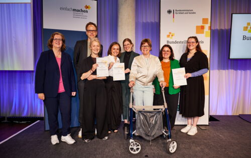 Ein Gruppenbild zeigt sechs Frauen und einen Mann: Ihre Projekte haben den Bundesteilhabepreis 2026 gewonnen. Links im Bild die Parlamentarische Staatssekretärin Kerstin Griese.