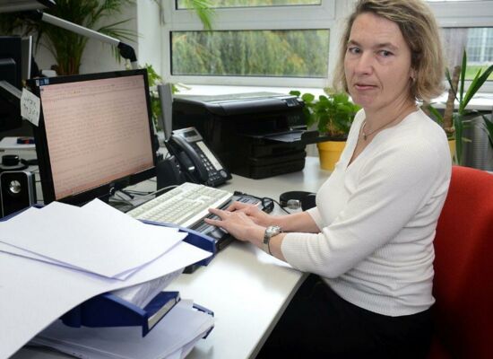 Christine Günzel steckt in ihrem Büro die „Tagesnachrichten“ – mit Braille bedruckte Bögen – in einen großen Umschlag. Auf dem Schreibtisch liegen bereits mehrere befüllte Umschläge.