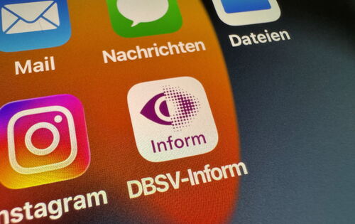 Auf einem Smartphone-Display sind verschiedene Apps zu sehen. In der Mitte die DBSV-Inform-App mit dem purpurnen Rasterauge auf weißem Grund.
