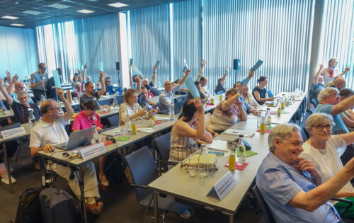 An langen Tischreihen sitzen die Delegierten des DBSV-Verbandstags. Vereinzelt halten sie Wahlkarten hoch.