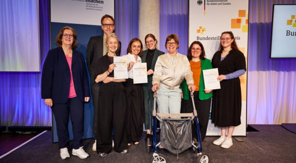 Ein Gruppenbild zeigt sechs Frauen und einen Mann: Ihre Projekte haben den Bundesteilhabepreis 2026 gewonnen. Links im Bild die Parlamentarische Staatssekretärin Kerstin Griese.
