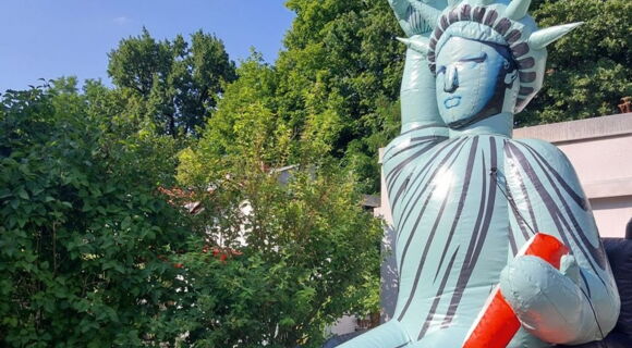 Eine fünf Meter hohe Figur der Freiheitsstatue sitzt in einem Rollstuhl, den rechten Arm mit der Fackel hoch erhoben.