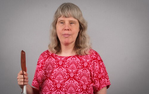 Andrea Katemann hat mittellanges helleres Haar und trägt einen Pony und ein T-Shirt mit floralem Muster.