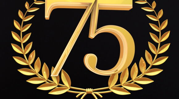Eine 75 in einem goldenen Zweigkranz. Der Hintergrund ist komplett schwarz