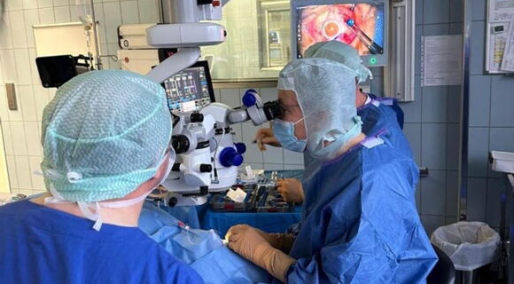 Prof. Dr. Frank Holz bei der Implantation des Port-Delivery-System mittels eines mikrochirurgischen Eingriffs im OP der Augenklinik bei einem Patienten mit AMD.