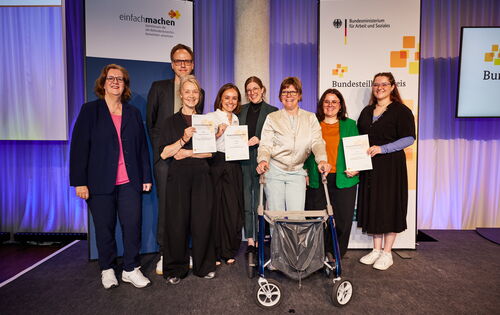 Ein Gruppenbild zeigt sechs Frauen und einen Mann: Ihre Projekte haben den Bundesteilhabepreis 2026 gewonnen. Links im Bild die Parlamentarische Staatssekretärin Kerstin Griese.