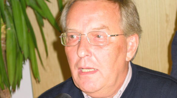Hans-Dieter Später spricht bei seinem Abschied vom DBSV. Er trägt einen dunkelblauen Pullover und eine schlichte Brille mit silbernem Rahmen.