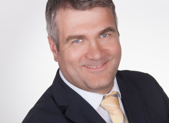 Markus Ertl blickt offen lächelnd in die Kamera. Er hat dunkleres volles Haar mit einem Seitenscheitel, trägt ein Hemd und ein Trachtensakko.