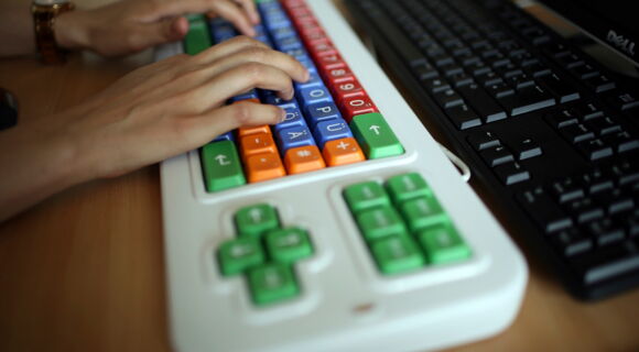 Das Bild zeigt die Hände eines Benutzers, der eine Tastatur bedient.