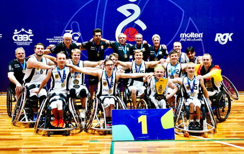 Gruppenfoto des Para-Teams 2025 der U23 Rollstuhlbasketballmannschaft. Die Männer haben die Arme ausgebreitet, ihre Hände liegen jeweils auf den Schultern der Teamkollegen neben ihnen.