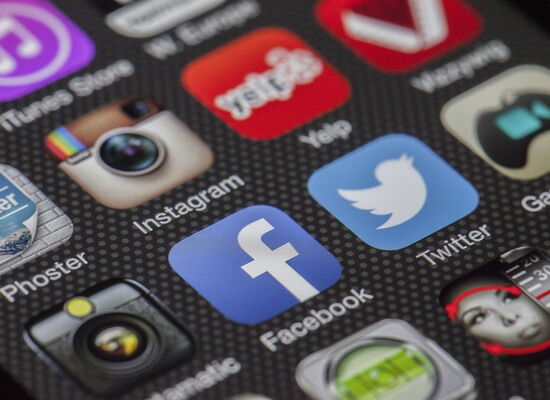 Der Bildschirm eines Smartphones zeigt mehrere Reihen von Symbolen für Social-Media-Plattformen, darunter Facebook, YouTube und Instagram.