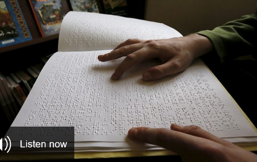 Screenshot der BBC-Webseite: Jemand liest mit den Händen ein Braille-Buch. In der linken unteren Ecke steht „Listen now“, englisch für „Jetzt anhören“.