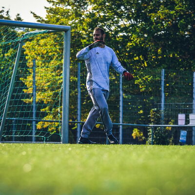 Onur Kinavli steht im Tor und dirigiert per Handzeichen seine Verteidigung. Er trägt ein blaues, langärmliges Trikot.