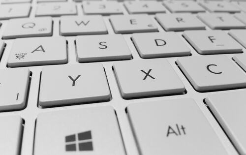 Der Ausschnitt einer hellen Tastatur ist zu sehen. Im Fokus ist die Windows-Taste.