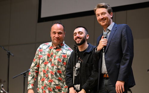 Die drei Comedians Khalil Khalil, Timur Turga und Jochen Prang stehen nebeneinander auf einer Bühne und lachen in die Kamera.