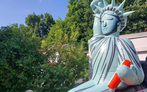 Eine fünf Meter hohe Figur der Freiheitsstatue sitzt in einem Rollstuhl, den rechten Arm mit der Fackel hoch erhoben.